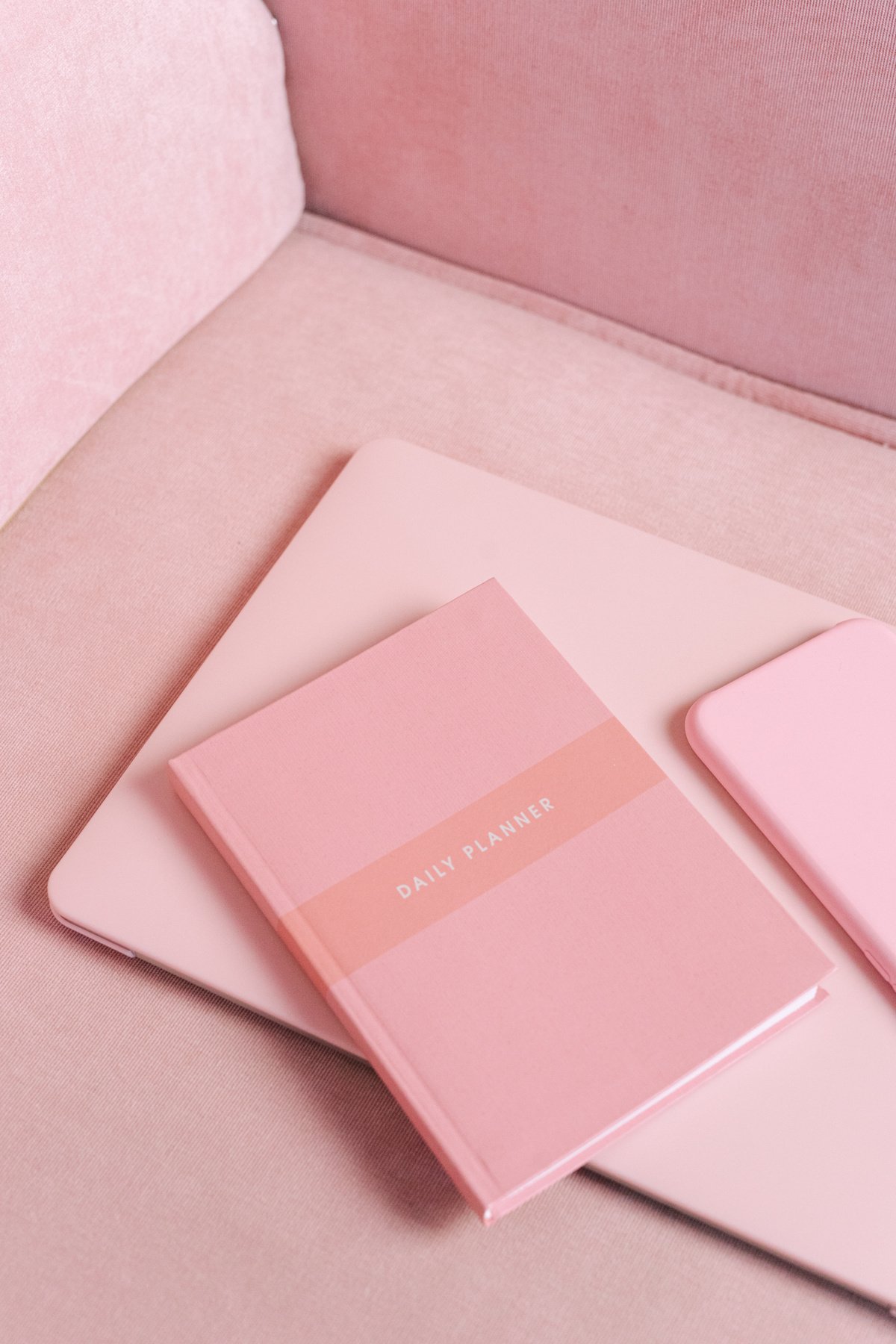 a pink notebook, a pink phone case, and a pink notebook