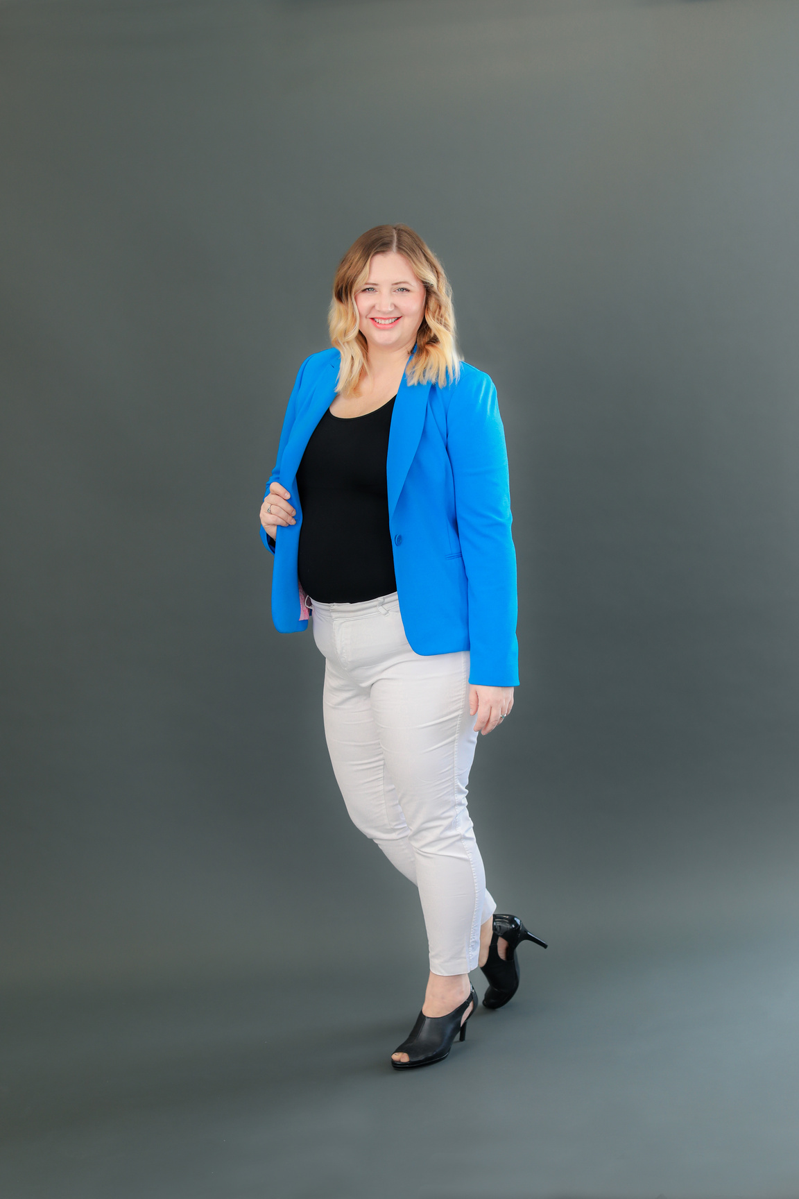 a person in a blue blazer and white jeans