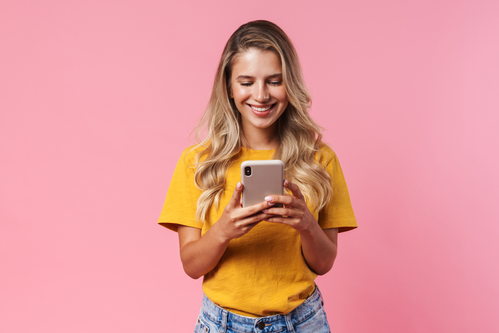 a person in yellow shirt holding a cell phone 